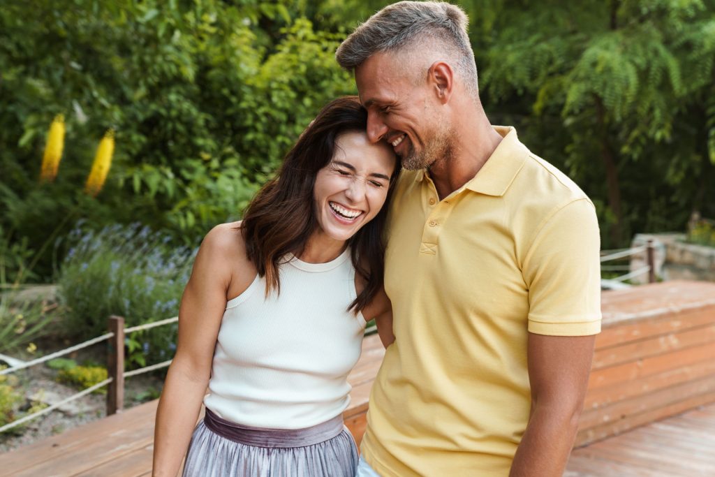 Happy couple hugging outside.
