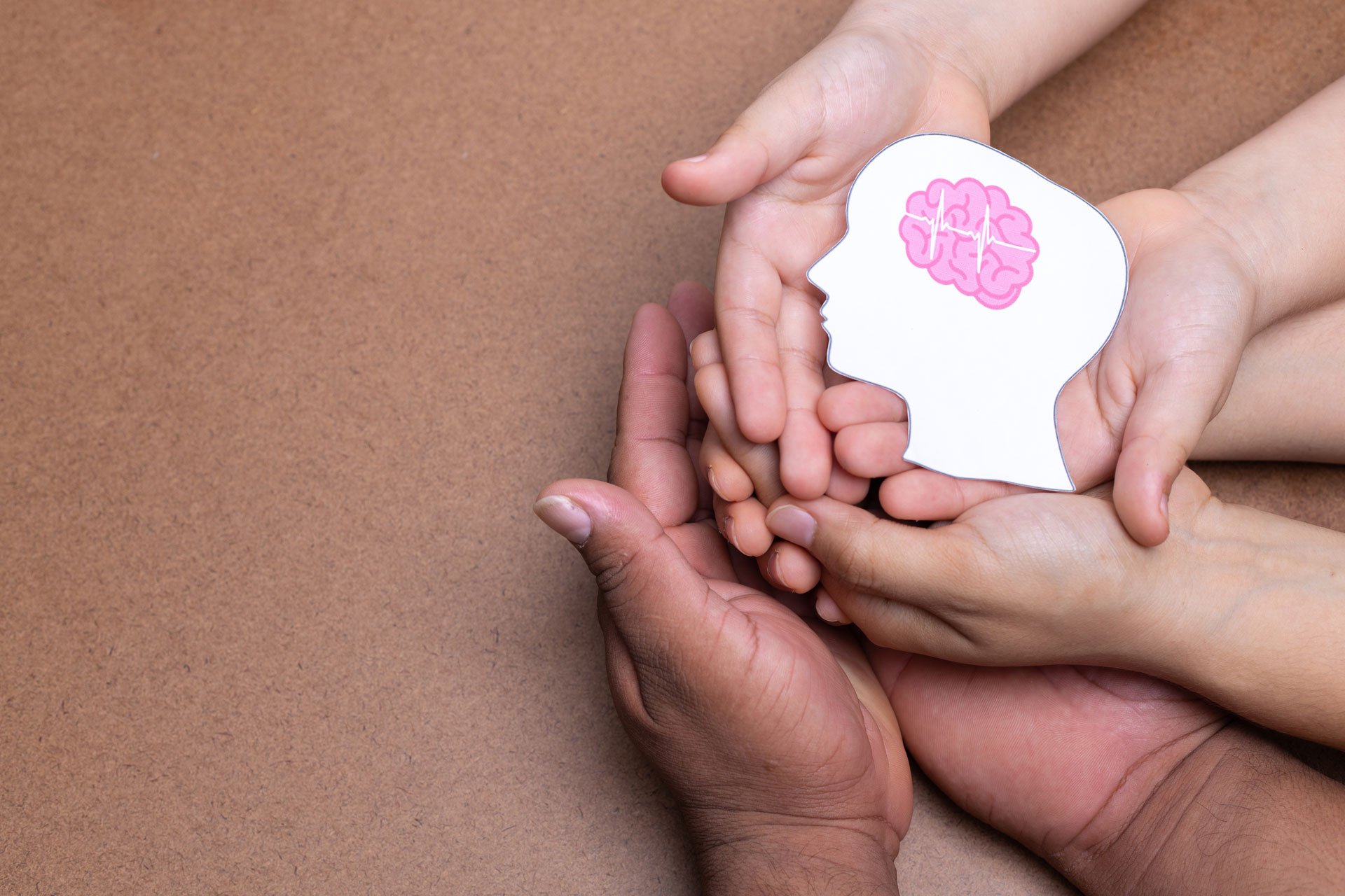 Hands holding head image with pink brain.