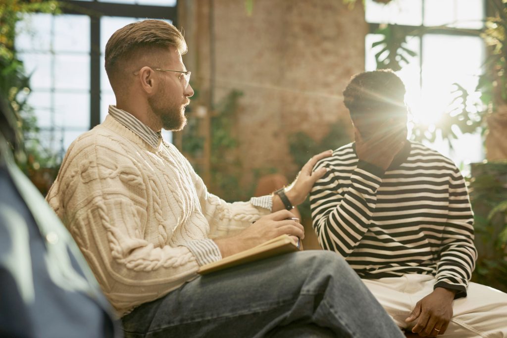 Male therapists comforts his patient while having a Cognitive Behavioral Therapy.