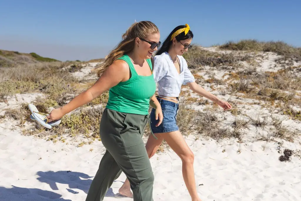 Two woman doing a walk and talk therapy in the beach.