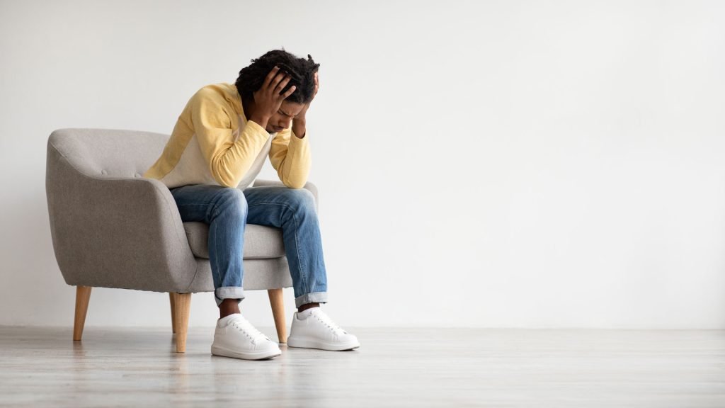 Depressed man sitting in a couch.