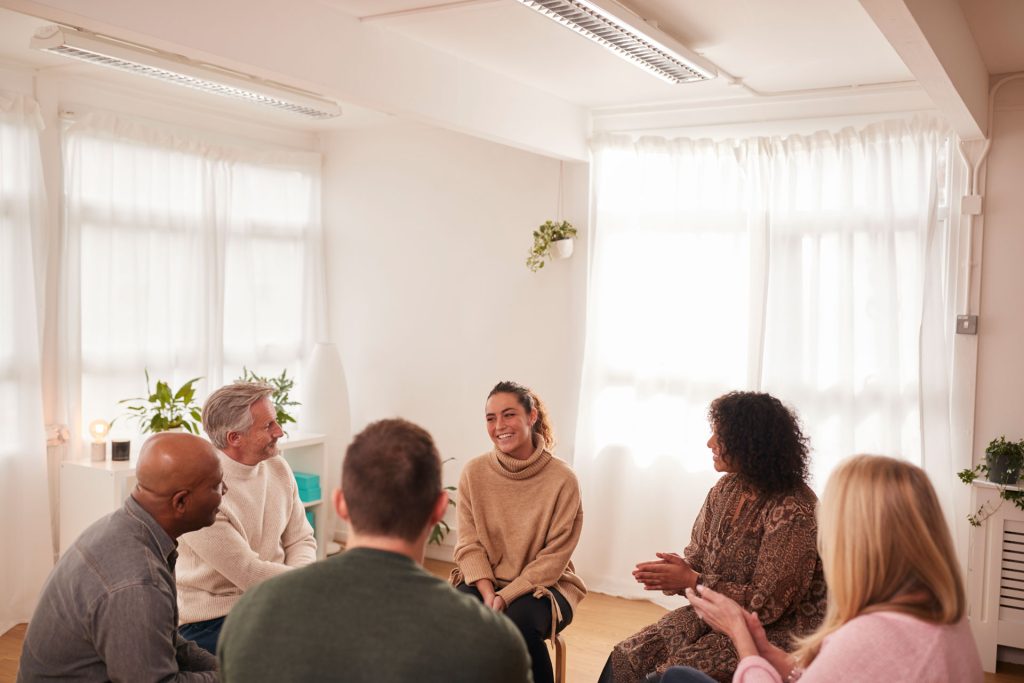 Woman speaking in a group meeting about mental health education.