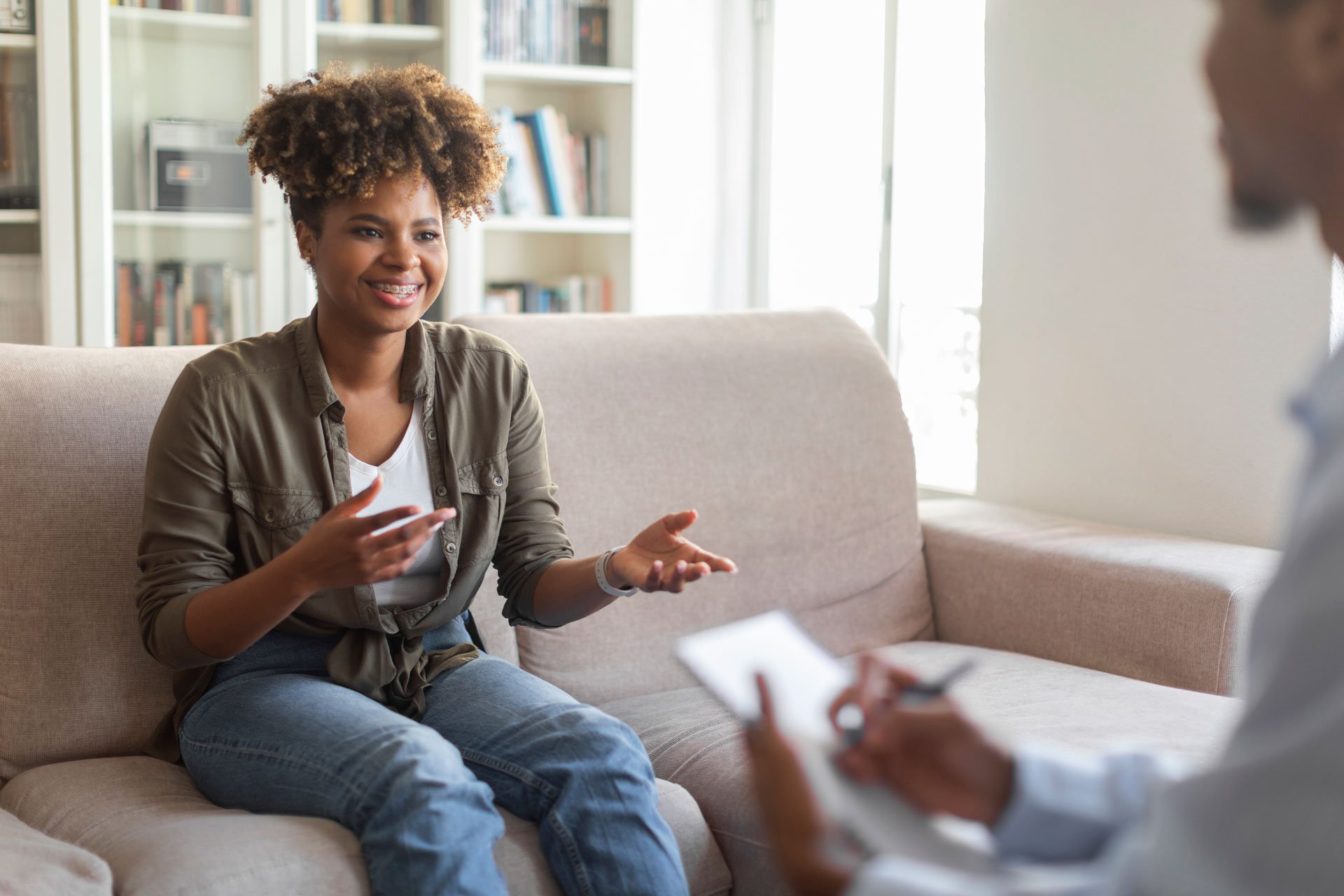 Happy african-american woman speaking with a therapist.