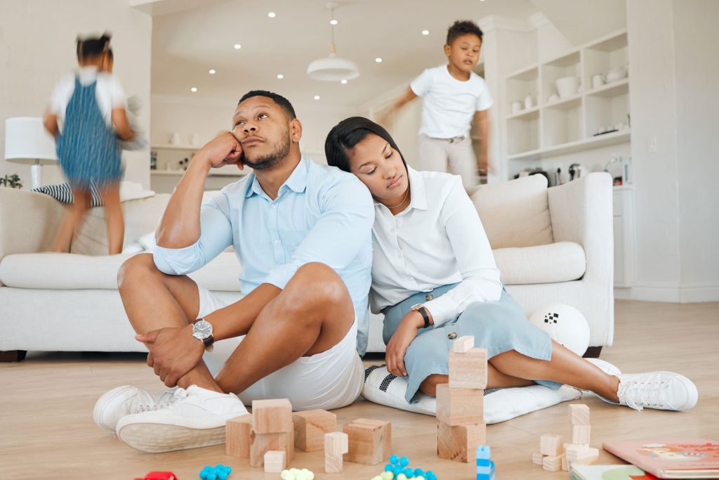 Young couple looking stressed with their child.