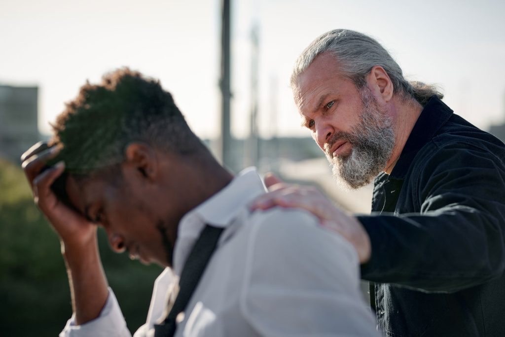 Man trying to help a guy suffering from grief.