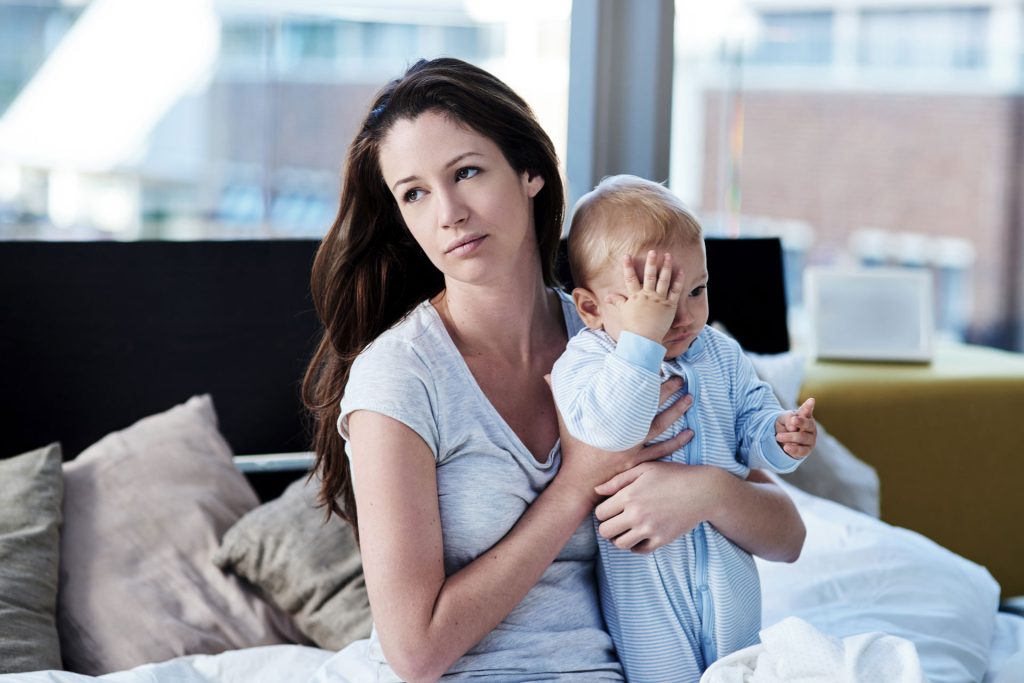 Mother with postpartum depression holding her baby.