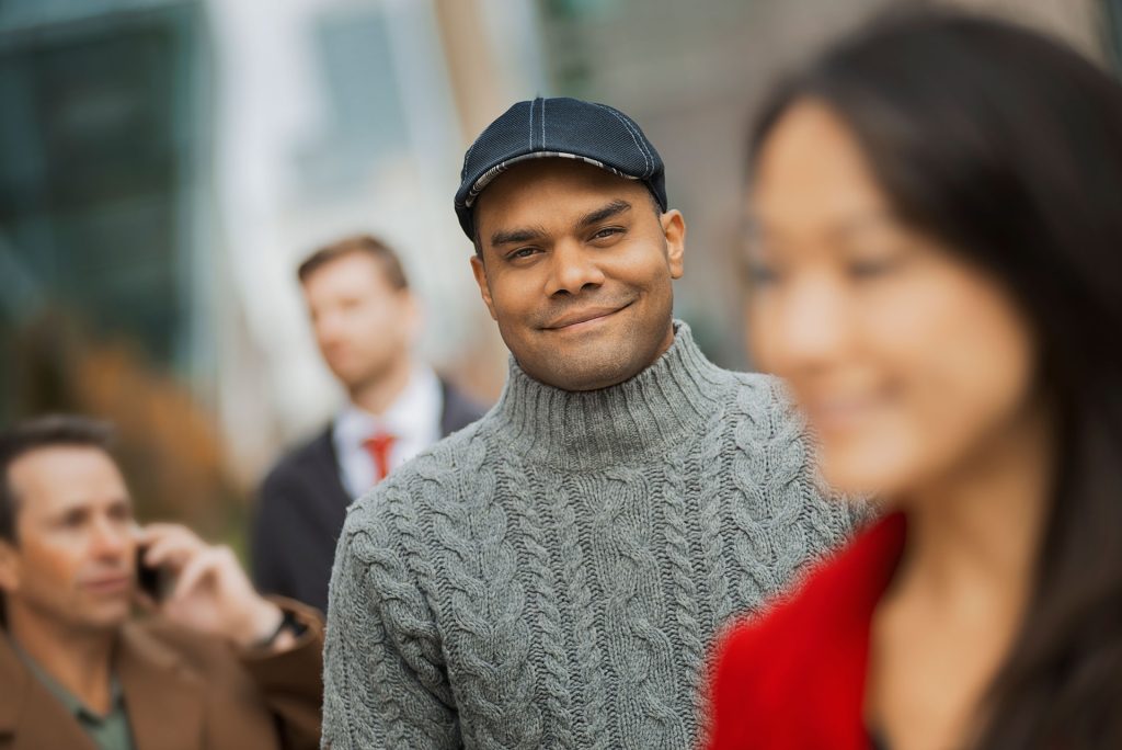 A happy man walking in crowd.